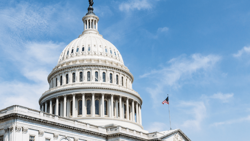 The top of the United States Capitol set against a blue sky with wispy clouds.